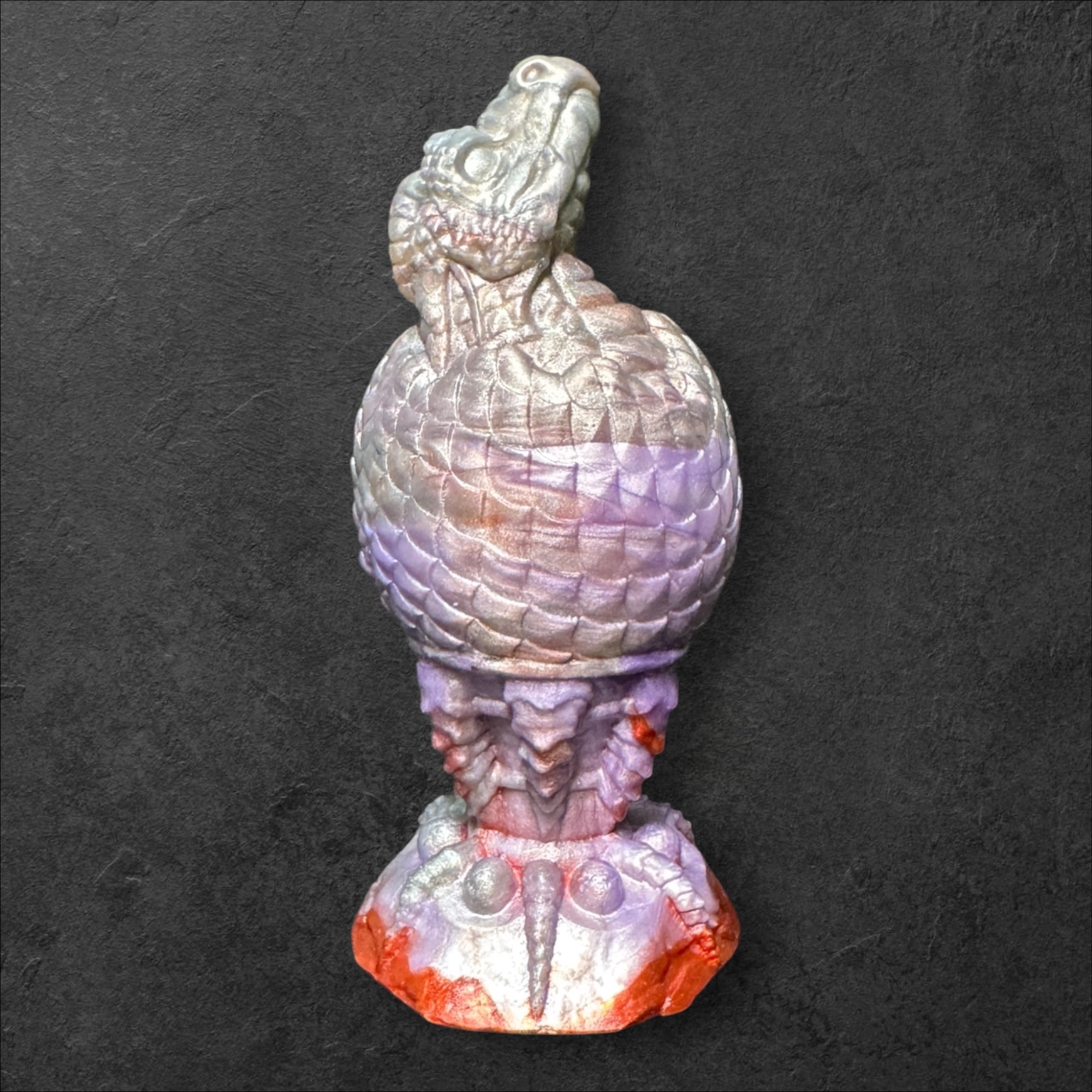The Fire Egg Fantasy Plug. Textured dragon egg with hatching head at the tip and sculpted dragon claw safety base. Platinum Silicone by ClimaxLab.