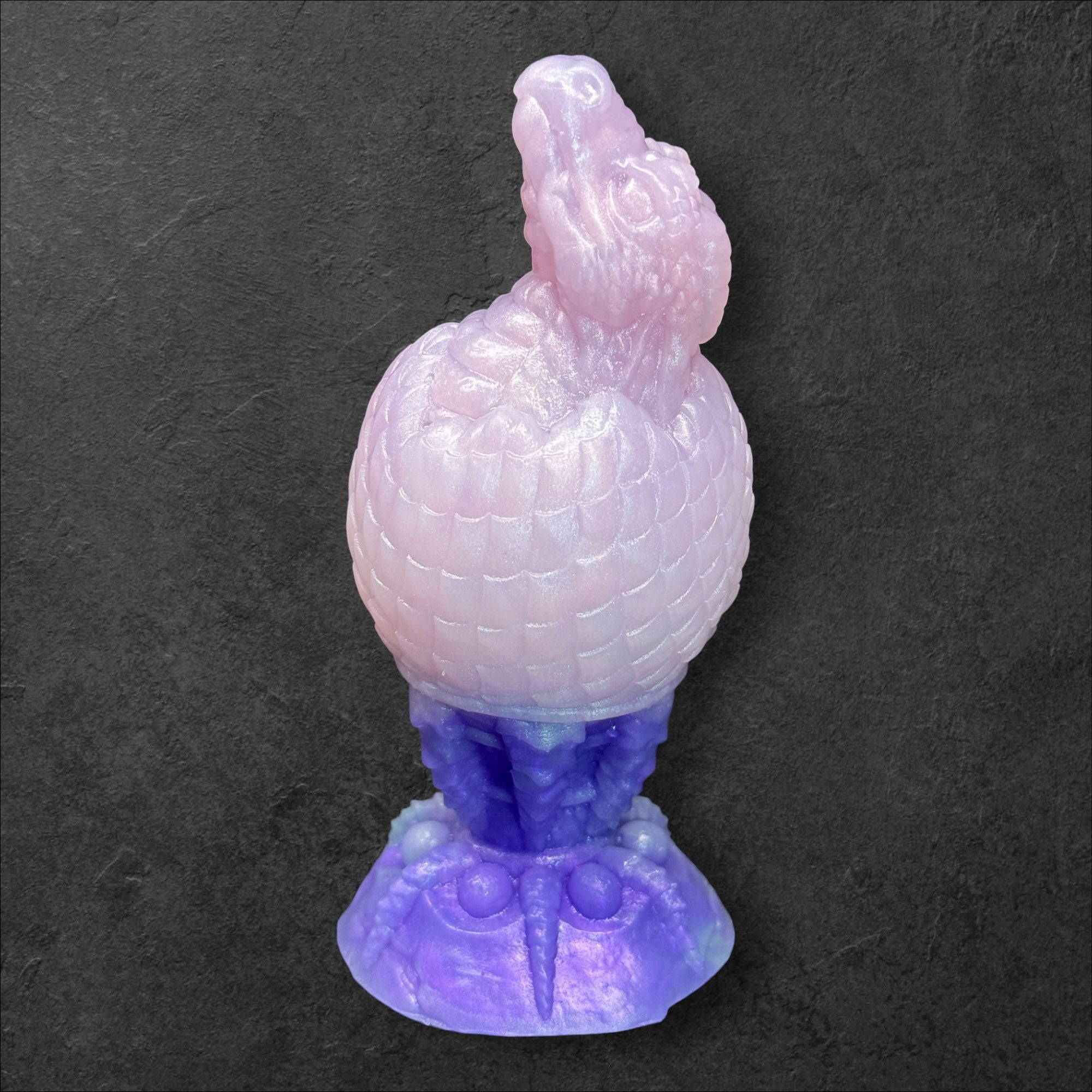 The Fire Egg Fantasy Plug. Textured dragon egg with hatching head at the tip and sculpted dragon claw safety base. Platinum Silicone by ClimaxLab.