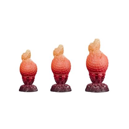 Huevo del Fuego · comparación proporcional Pequeño, Mediano y Grande, de izquierda a derecha. Render del mismo degradado burdeos, rojo, naranja y ámbar; sin fondo.